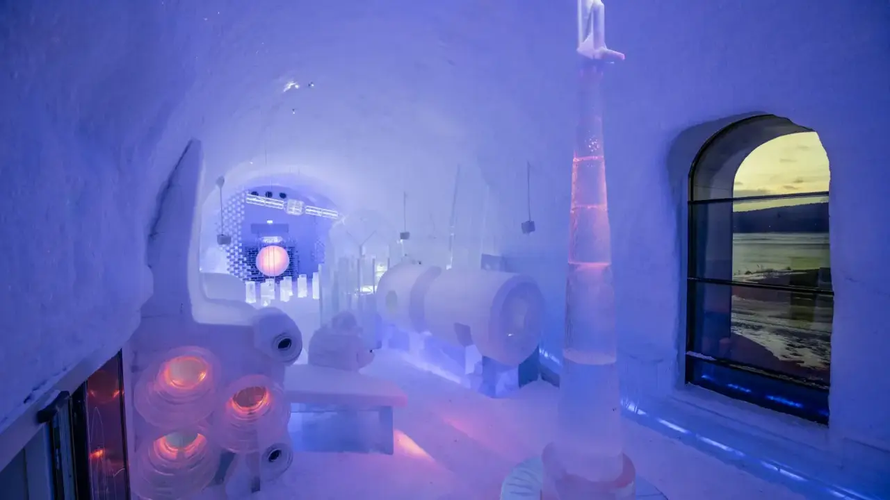 En ishall på Icehotel Kiruna med en rymdinspirerad skulptur och en stor sfär.