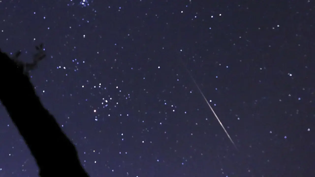 En stjärnklar natt med en meteor som drar en ljusstrimma över himlen, ett av många olika ljusfenomen på himlen.