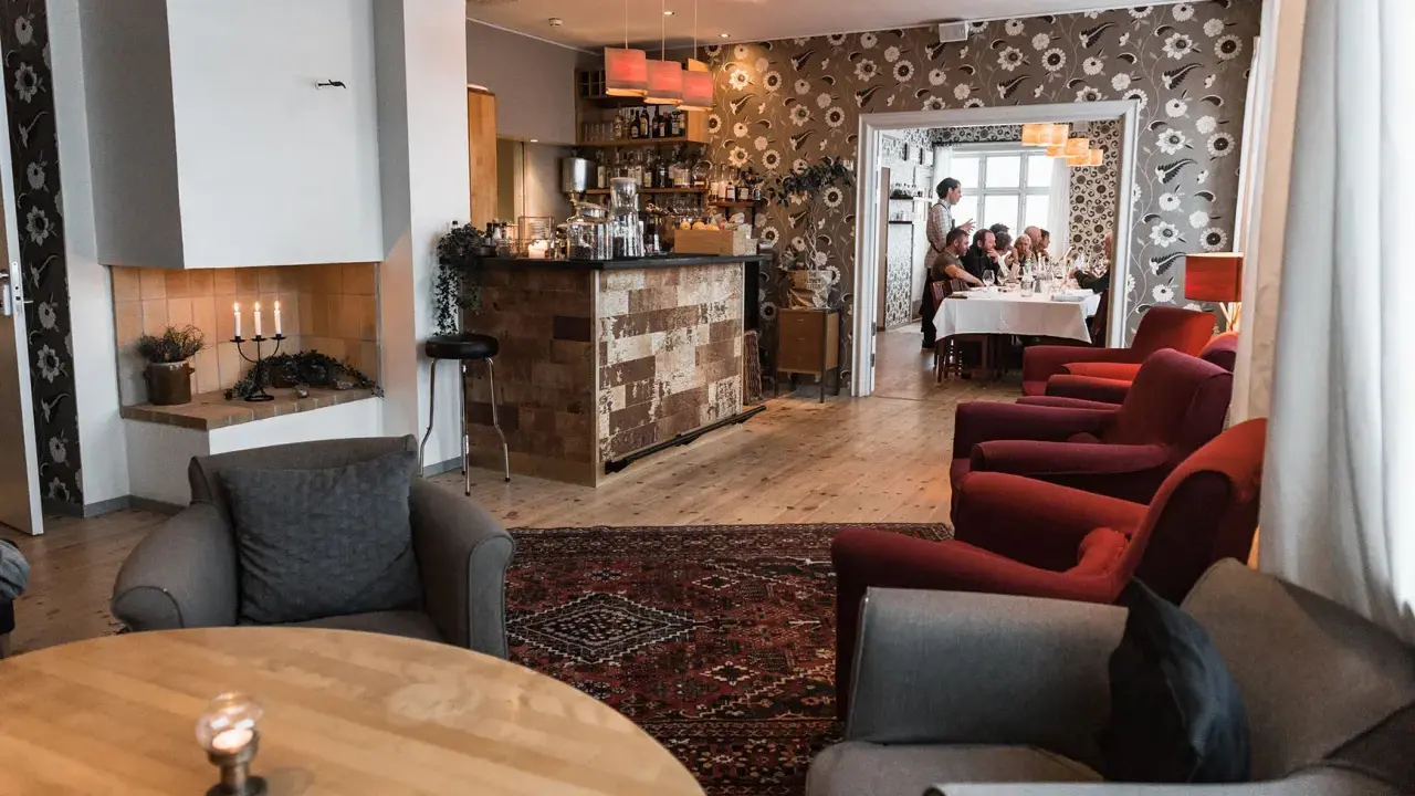 Mysig interiör på meteorologen ski lodge med öppen spis, bar och gäster som äter middag.