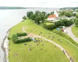 En grupp människor njuter av en paus under sin vandring i Danmark. En kyrka med tegeltak syns i bakgrunden.