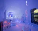 En ishall på Icehotel Kiruna med en rymdinspirerad skulptur och en stor sfär.