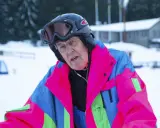 Äldre man i färgglad skidjacka och hjälm, redo för backen. Kanske en veteran från Edsbyn skidor.