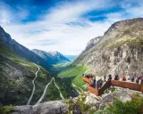 Besökare njuter av den dramatiska utsikten över Trollstigen i Åre, med en slingrande väg genom en grönskande dal.