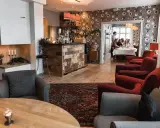 Mysig interiör på meteorologen ski lodge med öppen spis, bar och gäster som äter middag.