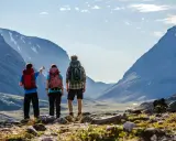 Vandrare med ryggsäckar njuter av den storslagna utsikten över fjällen under en abisko sommar.