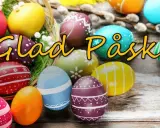 Färgglada påskägg i en korg och utspridda på träbord, med texten "Glad Påsk!". Perfekt för påsklov i Sverige.