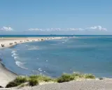 En vacker strandpromenad vid Skagen, med folk som njuter av solen och havet. En perfekt resa till Skagen.
