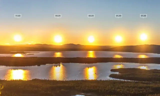 Solens resa över sjö och skog i Sverige under midnattssol.