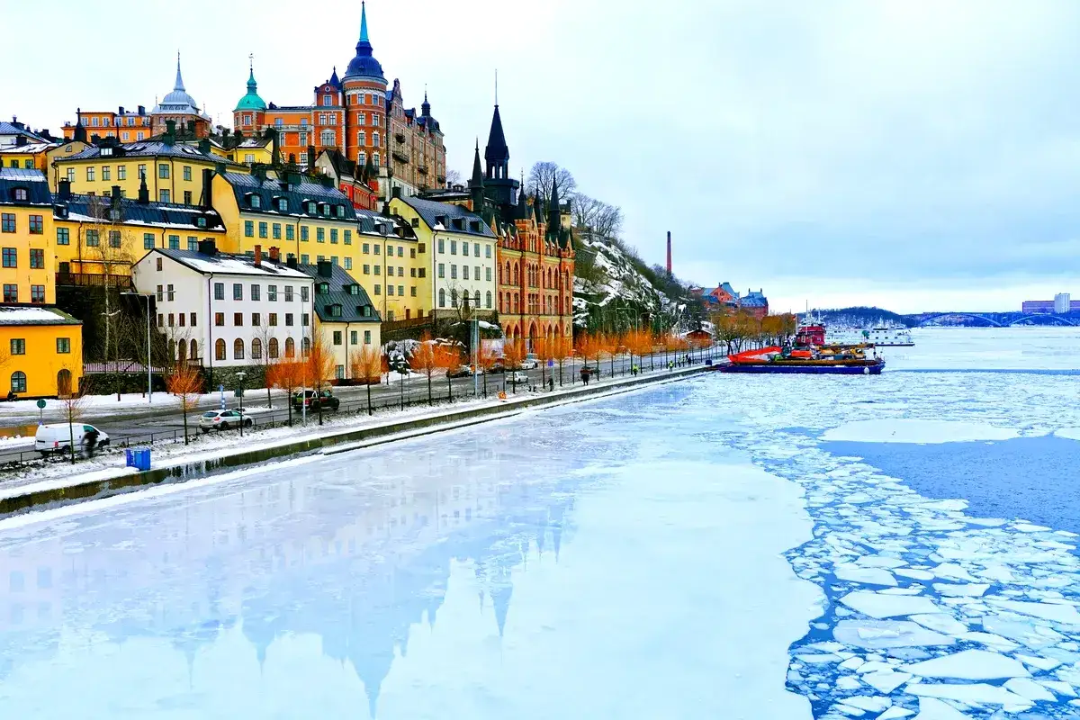 Färggranna hus längs en isig kaj i Stockholm, en påminnelse om den kortaste dagen i Sverige.