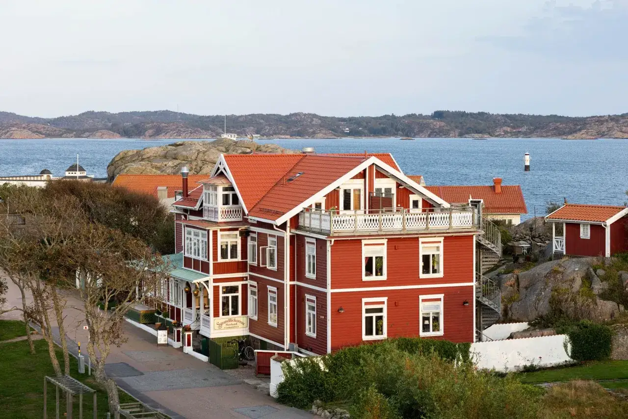 Röda trähus vid havet i Lysekil, där strandflickorna njuter av utsikten.