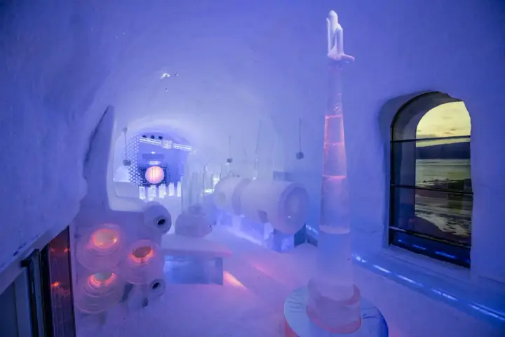 En ishall på Icehotel Kiruna med en rymdinspirerad skulptur och en stor sfär.